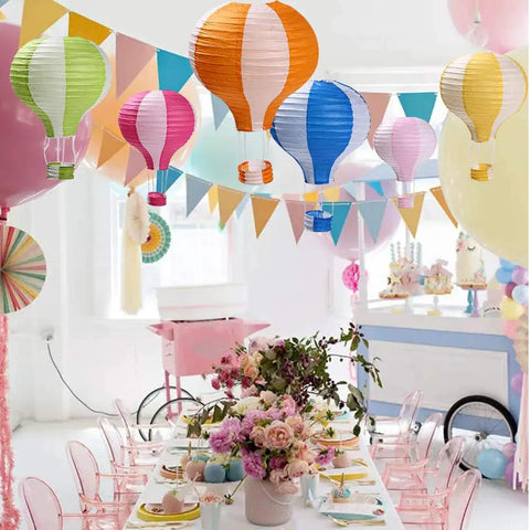 Hot Air Balloon Paper Lantern Decor Set Of 6 With Striped Blue Green Pink Orange Yellow Patterns 12 Inch Diameter And 16 Inch Expanded Height Perfect For Weddings Birthday Engagements Christmas Party Decor Party Ready Vibe hanging in decorated party room with table setting.
