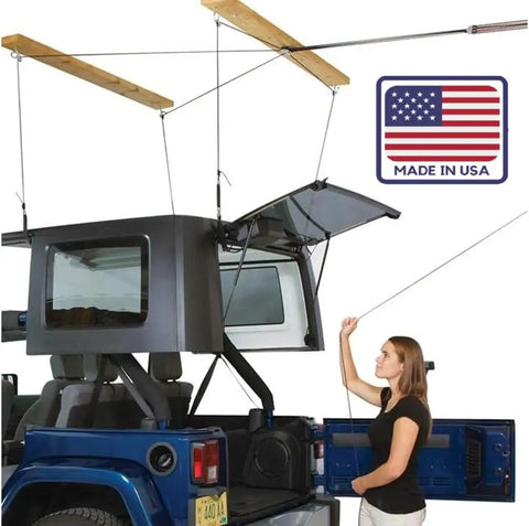 Overhead Truck Cap Garage Hoist With Self-Leveling Lift Safe Anti-Drop System One-Person Operation 12-Foot Ceiling Ready 200 Lb Capacity Four-Point Kit Made In USA Easy Install shows a woman operating the hoist.