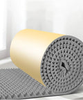 Peel And Stick Soundproofing Foam Roll For Walls Thick Acoustic Dampening Panels Fireproof Noise Blocker Mat For Home Studio Audio Treatment Grey rolled up on surface.