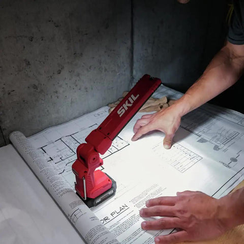 Heavy Duty Led Work Light 12 Volt Compact Task Lamp illuminating blueprints on a workspace with a rugged design.