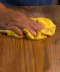Game Changer Pre Treated Wood Furniture Dusting Cloths Pack Of Five Lint Free Wipes being used on wood surface.