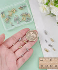 Must Have Cord End Caps Set For Jewelry Making 48 Pieces Brass End Caps With Loops next to a ruler and coin for scale.