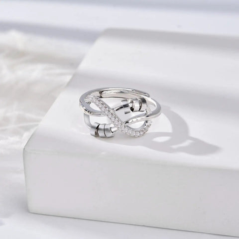 Silver fidget ring with knot design and spinning beads, showcased on a white surface for stress relief and focus.