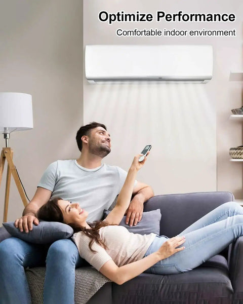 Couple relaxing on couch with remote controlling wall-mounted air conditioner