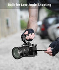 Person using Lightweight NATO Top Handle For DSLR Camera Cages With Quick Release Universal Top Grip for low-angle shot