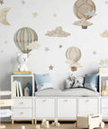 Watercolor Hot Air Balloon Fabric Wall Sticker Peel and Stick Decals With Stars and Clouds for Baby Nursery Kids Bedroom Playroom Decor 120 x 40 cm Eco Friendly Non Toxic Pre Cut Totally Kid Friendly applied on a nursery wall.