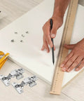 Person measuring wood panel with ruler and pencil, Soft Closing Frameless Cabinet Hinges Two Pack For Replacement Doors visible nearby