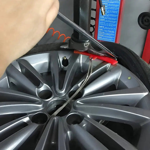 Red 5 Piece Tire Changer Rim Protectors Premium Soft Polyurethane Wheel Savers on a shiny silver wheel during tire change.
