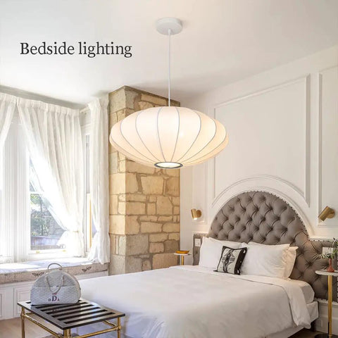 Bedroom with Italian Silkworm Cocoon Pendant Light With White Faux Silk Drum Shade hanging above a bed, showcasing minimalist style.