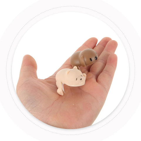 Hand holding silicone animal shape corner protectors, part of Four Pack Silicone Animal Shape Corner Protectors For Furniture Anti Collision Edge Guards Easy To Install No Tools Needed Kid Safe Baby Proofing Bumpers For Tables Desks And Cabinets Durable And Safe.