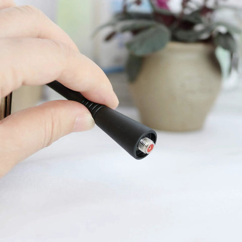 Close-up of 10 Pack UHF Whip Antenna 6.5 Inch Replacement For VX Series Radios showing connector end held in hand