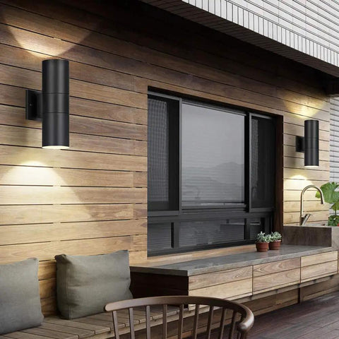 Dusk To Dawn Outdoor Wall Light With Up And Down Lighting, LED A19 Bulbs Included, featured on a wooden porch wall, matte black finish.