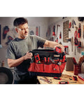 VersaStack Zippered Tool Bag With 31 Pocket Organizer held by man in workshop, showcasing durable 1680 denier fabric and tools.