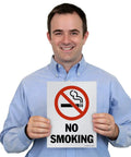 Man holding a No Smoking sign, Pack Of Five Beefy 12 X 9 Inch No Smoking Signs Bold Warning Icon Screen Printed On Sturdy 10 Mil Polystyrene Plastic Indoor Or Outdoor Ready Weather Tough Zero Fuss Quick Staple Install Everyday Reliable Made In Usa.