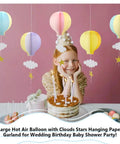 Colorful Hot Air Balloon Paper Garland Set 5 Pieces For Room Party Decor With Clouds And Stars Easy To Hang Festive Wedding Birthday Shower Fun Backdrop Perfect For Baby Showers And More hanging above a birthday cake and child.