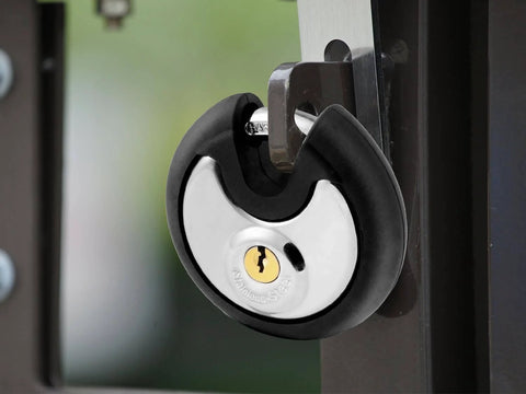 Outdoor Stainless Steel Disc Padlock With Waterproof Shield And Rubber Bumper installed on gate for security