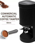 Automatic Electric Coffee Tamper 58mm with durable metal frame and black design, next to a portafilter and ground coffee.