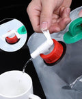 Pouring water from 20L Portable Water Storage Container for Outdoor Activities into a cup, dual handles visible