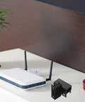 Under Desk Laptop Holder Sliding Bracket Fits All Laptops Clears Desk Mess Instantly Black Plastic Mount next to router on desk