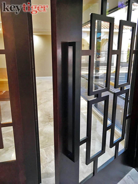 24 Inch Back To Back Modern Stainless Steel Door Handle Set In Matte Black Finish For Interior And Exterior Doors, installed on glass door.