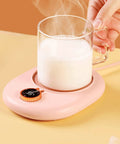 Grab And Go Cup Warmer Heating Pad With Dual Temperature Controls keeps milk steaming hot, featuring a pink design and temperature dial.