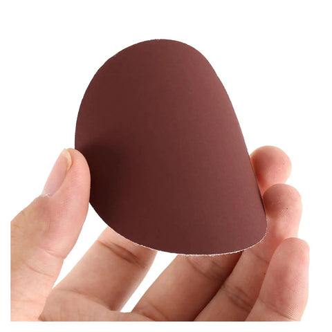 Hand holding a brown sanding disc from the Super Smooth Sandpaper Kit With 100 Ultra Versatile Grit Sanding Discs And Backers For Polishing Metal Wood Paint Glass Leather Plus Stone Fast Rust Removal And Deep Cleaning.