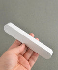 Hand holding one piece from 5 Pack Matte White Cabinet Handles For Kitchen Cabinets And Furniture Modern Drawer Pulls Center To Center Five Inches Length Five Point Nine Inches Width About One Inch Ideal For Kitchen Cabinets Bathroom Vanities Dressers And Closets
