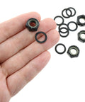 Hand holding washers and nuts from Two Sets Black Imperial Hex M8 Skateboard Side Nut Washers With Non Slip Rubber Ring Built Tough
