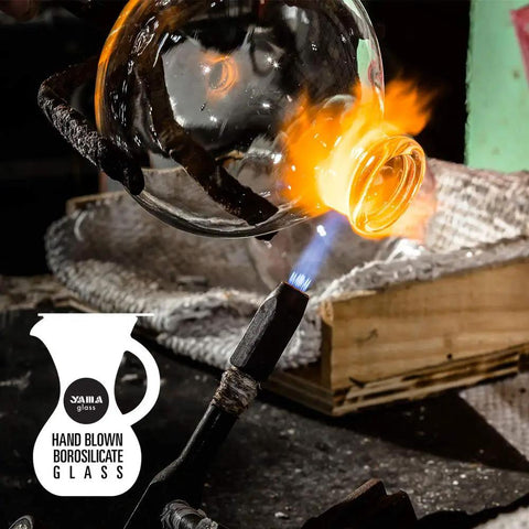 Hand-blown glass being shaped over a flame, illustrating craftsmanship in Three Cup Tabletop Siphon Coffee Maker With Alcohol Burner Gravity Brew For Clean Rich Smooth Coffee And Aromas Safe Sleek Stand Vacuum Seal Technology Lets You Brew On Your Counter.