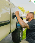 Man using All In One Car Polish And Wax That Corrects Scratches And Swirls Provides Clear Coat Safe Sealant And A High Gloss Finish Easy One Step Application 16oz Made In USA on truck door