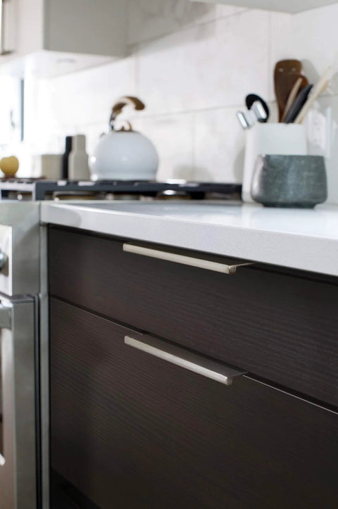 Emtek Edge 8 Inch Center To Center Finger Cabinet Pull 87130US4 installed on modern kitchen drawers, sleek design