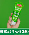 Hand holding a tube of Working Hands Hand Cream, 3 oz, green packaging, for extremely dry cracked hands.