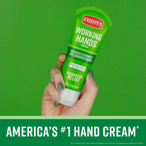 Hand holding a tube of Working Hands Hand Cream, 3 oz, green packaging, for extremely dry cracked hands.