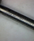 Close-up of a metal axle for derby cars, ideal for applying Graphite Dry Lube For Wood Derby Cars With Tungsten Moly Boron Blend.
