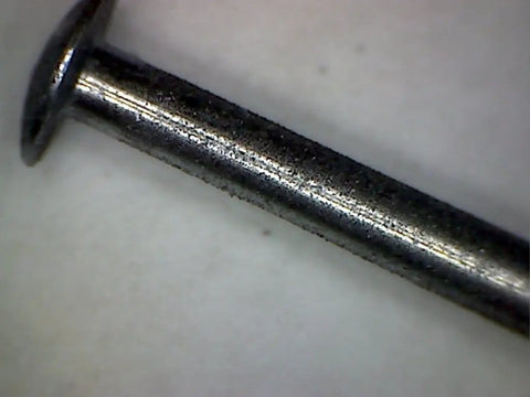 Close-up of a metal axle for derby cars, ideal for applying Graphite Dry Lube For Wood Derby Cars With Tungsten Moly Boron Blend.