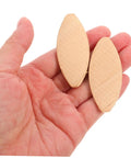 Top Shelf Wood Joining Biscuits And Joint Plates For Zero Hassle Furniture Assembly in a hand, light yellow hardwood cutouts for alignment.