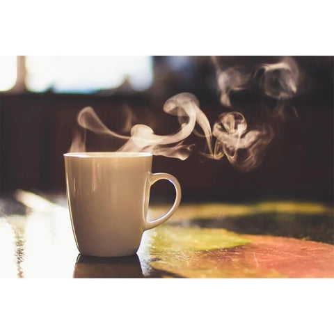 Steaming white coffee mug on table suggesting use of Water Filter Softener DLSC002 For Delonghi Espresso And Bean To Cup Machines Helps Reduce Limescale Boost Coffee Quality Improve Machine Performance Extend Lifespan Replaces SER3017 For ECAM BCO420 BCO410 Series.