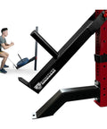 Man using Squat Lever Arm Plate Loaded Gym Equipment Go To Belt Squats Curls Rows And Guided Deadlifts Fits 3x3 Racks With 5/8 Inch Or Larger Holes Black Powder Coated 11 Gauge Steel for squats on a red rack.