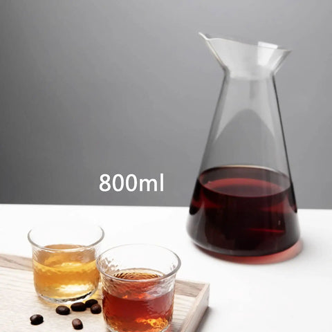 Top Tier Iced Coffee Maker And Cold Brew Drip Tower With 800Ml Borosilicate Glass Pitcher displayed with drinks and coffee beans.