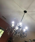 Bronze Crystal Six Light Candle Chandelier With Metal Pendant Ceiling Light illuminating a room, vintage bronze finish