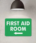 Left Arrow First Aid Room Outdoor Medical Safety Sign 8x12 Aluminum under lamp on wall