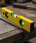 Spirit Level, Aluminum Alloy, 250mm measuring precision with green vials on a work surface.