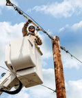 Worker using Beefy Web Strap Ratchet Hoist With Non Conductive Dial For Easy Slack Adjustment, 360 Rotating Handle on utility pole