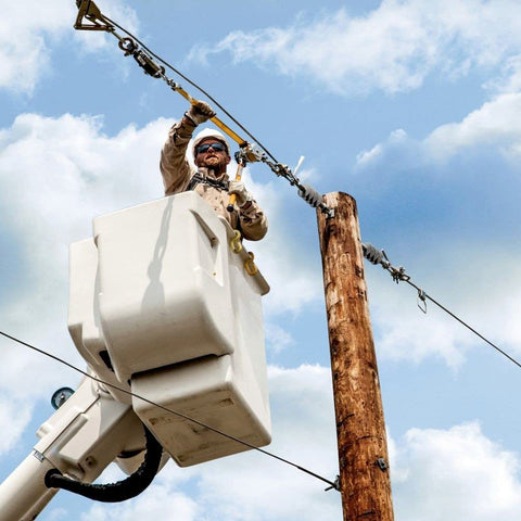 Worker using Beefy Web Strap Ratchet Hoist With Non Conductive Dial For Easy Slack Adjustment, 360 Rotating Handle on utility pole