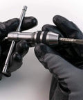 Two Piece Tap Wrench Set with Sliding T Handle and Reference Table for Zero to One Half Inch Taps held in gloved hands
