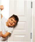 Residential door spring hinge on white interior door; boy peeks through doorway