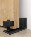 Flush Floor Sliding Barn Door Roller Guide Set With Wall Mounted Hardware installed on wooden door, black steel base
