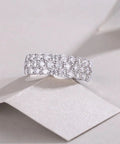 Top Shelf Moissanite Grid Pattern Engagement Ring Platinum Plated 925 Sterling Silver with round cut stones on a display.