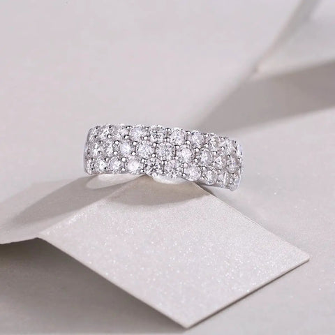 Top Shelf Moissanite Grid Pattern Engagement Ring Platinum Plated 925 Sterling Silver with round cut stones on a display.