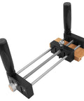 Small Stock Holder For Router Tables That Secures Tiny Wood Pieces And Lets You Feed Wood Safely Keeping Fingers Clear And Delivers Precise Freehand Cuts On Any Router Table, showing metal rods and black handles with wood piece secured.
